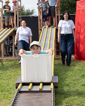 Ein Kind fährt beim Hütte Rockt Kids die vereinseigene Kistenrodelbahn herunter
